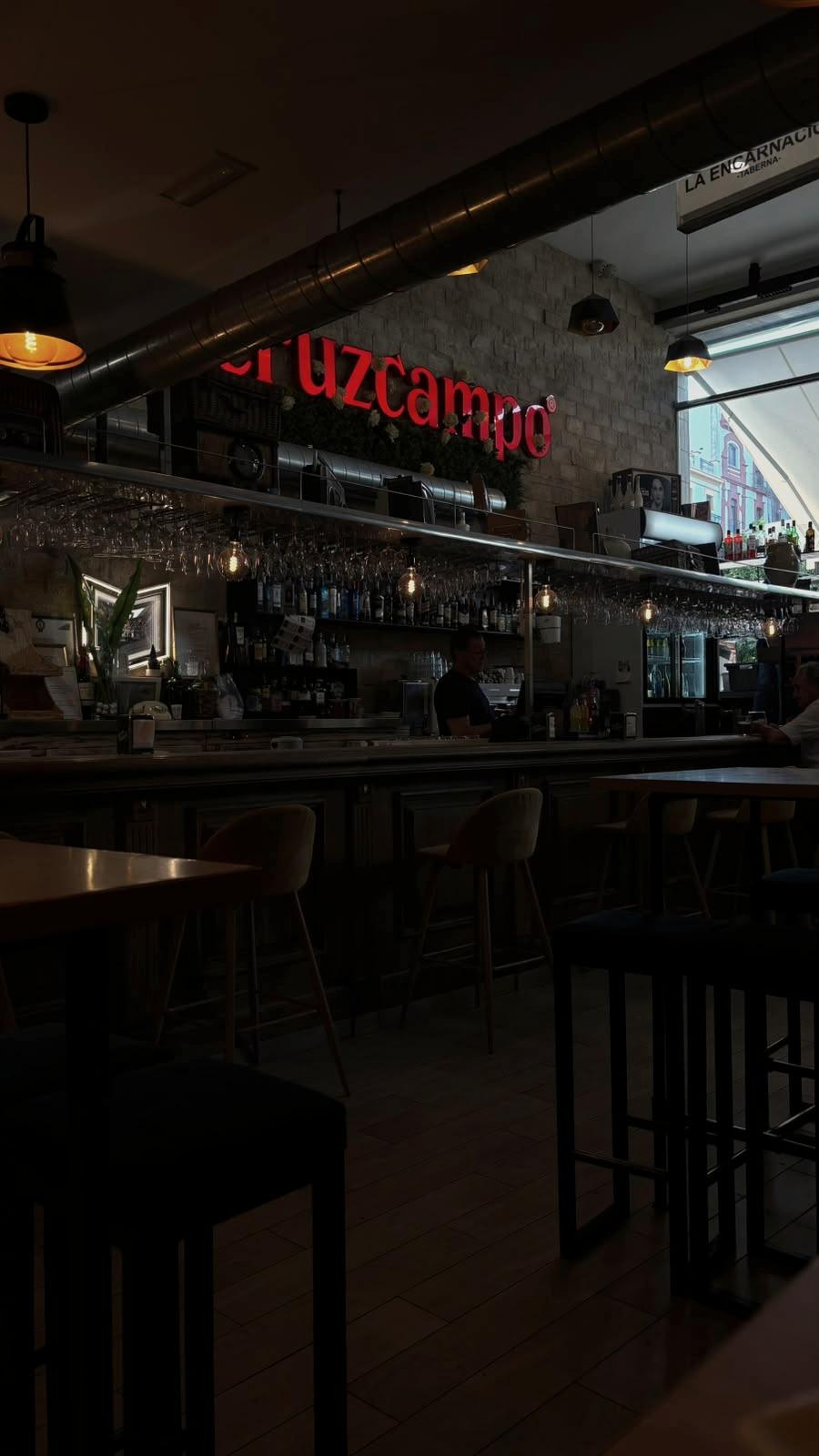 O interior de um bar, ao fim da tarde.