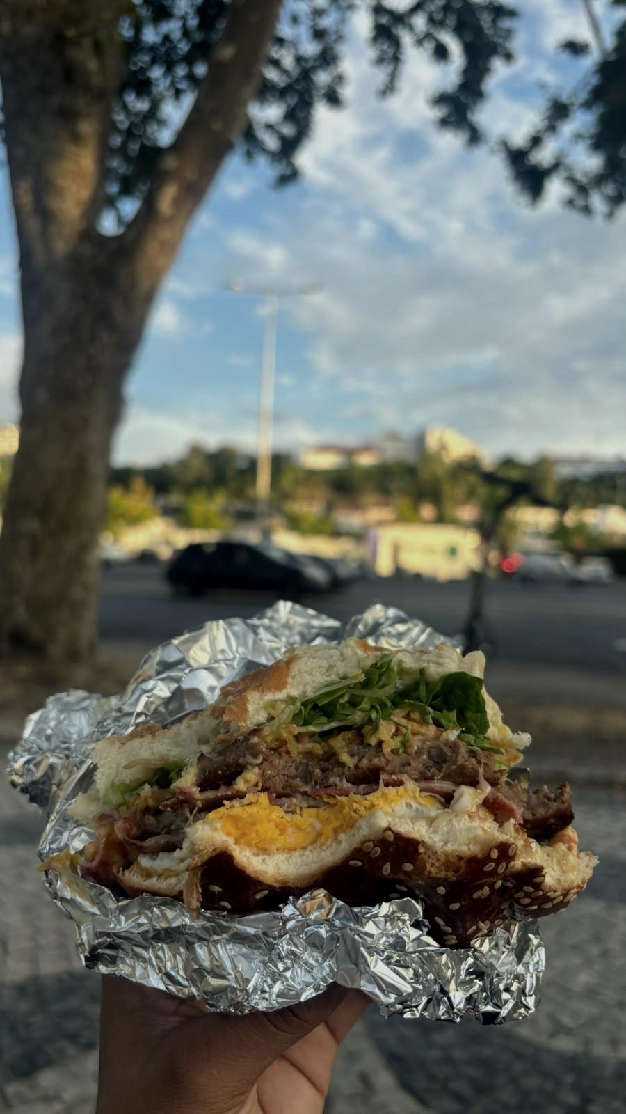 Uma sandes embrulhada em papel de alumínio, à mesa na rua.